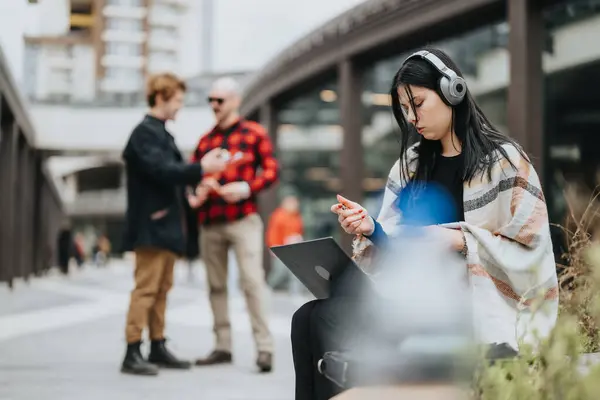 Focused Woman Headphones Using Laptop Business Colleagues Engage Discussion Outdoors — Stock Photo, Image