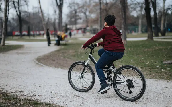 Niño Disfruta Andar Bicicleta Por Sendero Grava Parque Ciudad Rodeado —  Fotos de Stock