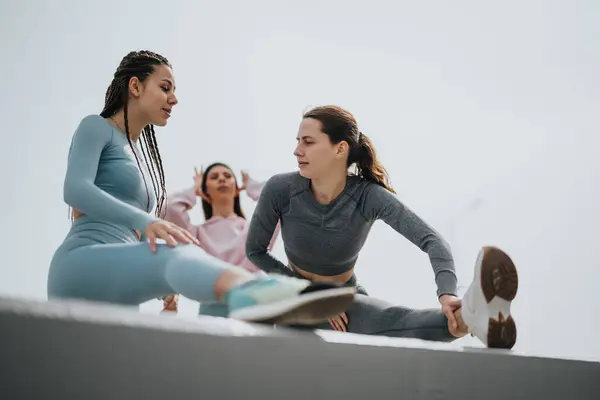 两名身穿运动服的有进取心的妇女伸展在室外 展示健康和健康 — 图库照片