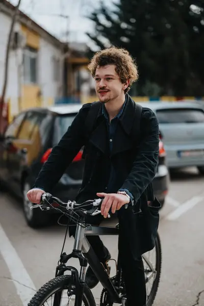 年轻的职业男子 卷曲的头发 穿着时髦的休闲装 骑着自行车在城市街道上穿梭 — 图库照片