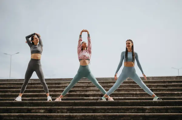 Drei Junge Frauen Führen Eine Dehnübung Auf Stufen Durch Sie — Stockfoto