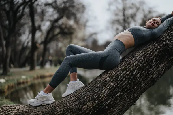 Sportif Genç Bir Kadın Doğada Çalışırken Bir Ağaç Gövdesine Mola — Stok fotoğraf