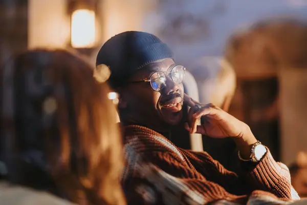 Hombre Con Estilo Gafas Disfrutando Conversación Ambiente Acogedor Por Noche — Foto de Stock