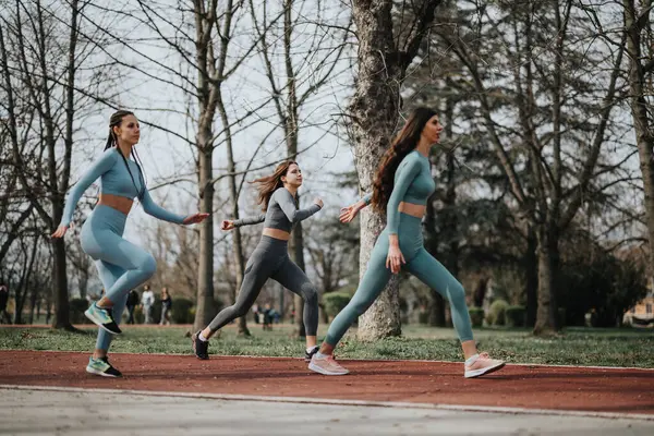Active Women Running Outdoors Track Surrounded Trees Displaying Energy Teamwork — Stock Photo, Image