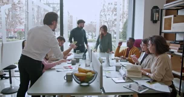 近代的なオフィスの設定でビジネスミーティング中に戦略ディスカッションに従事する企業従業員の多文化チーム — ストック動画