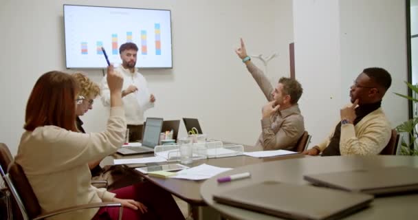 プロのグループがビジネスミーティングに参加し プレゼンテーション画面のカラフルなバーグラフをモダンなオフィス設定で調べる — ストック動画