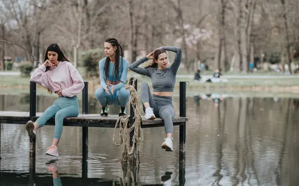 Candid Moment Capturing Three Young Women Unwind Dock Overlooking Tranquil — Stock Photo, Image