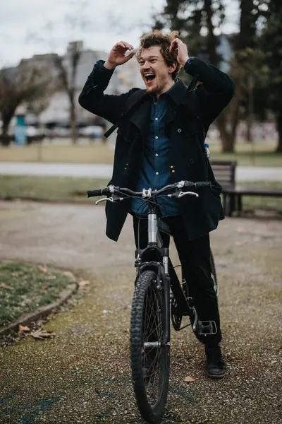自転車でカジュアルなビジネスの服装で陽気な男性のプロフェッショナルは 都市公園の設定で外でリラックスするのに時間がかかります — ストック写真