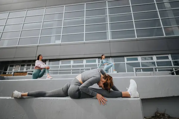 Drei Frauen Aktiver Kleidung Üben Dehnungen Auf Stufen Vor Einem — Stockfoto
