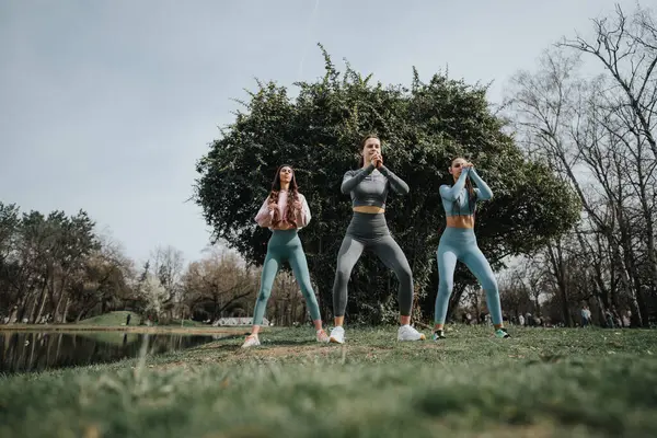 Three Female Athletes Performing Squats Exercising Outdoors Park Focusing Fitness — Stock Photo, Image