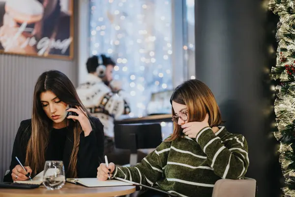 Twee Jonge Vrouwen Werken Intensief Samen Aan Een Cafe Tafel — Stockfoto