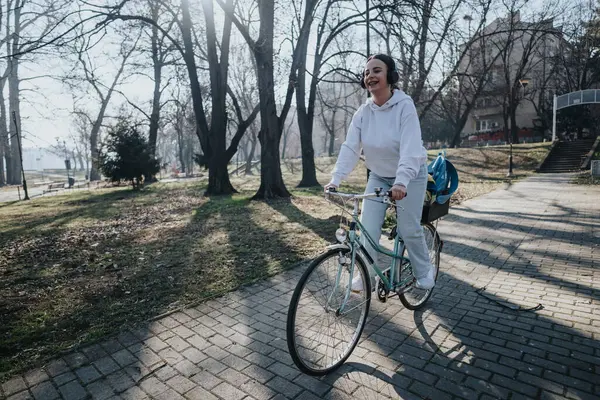 Una Mujer Disfruta Paseo Bicicleta Tranquilamente Través Parque Sereno Día —  Fotos de Stock