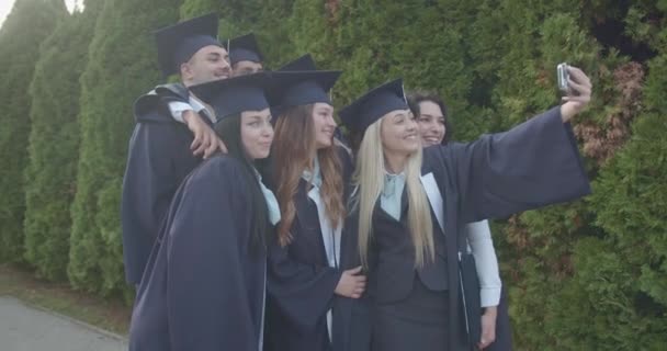 Emocjonujący Absolwenci Akademickich Strojach Uchwycili Niezapomniany Moment Selfie Parku Upamiętniając — Wideo stockowe