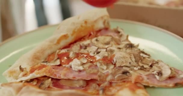 上に余分なソースが注がれているプレートにハムとキノコのピザの魅力的なスライス 楽しいファーストフードを表す — ストック動画