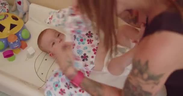 在医院接受体格检查后 年轻的母亲穿上衣服 与婴儿玩耍 — 图库视频影像