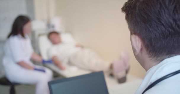 Медсестра Консультируется Своим Старшим Врачом Терапии Лечении Своего Молодого Пациента — стоковое видео