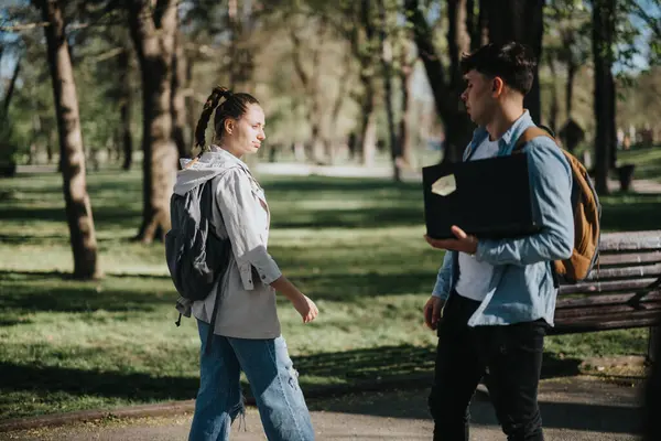 Två Unga Studenter Med Ryggsäckar Njuter Vänlig Konversation Medan Promenerar — Stockfoto