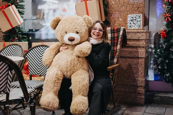 Happy Woman Embracing Large Teddy Bear Christmas Decorated Cafe — Stock Photo, Image
