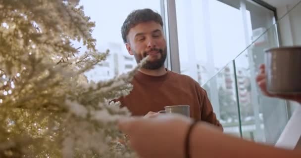 年轻的员工喜欢在明亮的办公室环境中 在一棵装饰过的圣诞树旁轻松地喝咖啡聊天 休息一下 营造一种节日和放松的氛围 — 图库视频影像