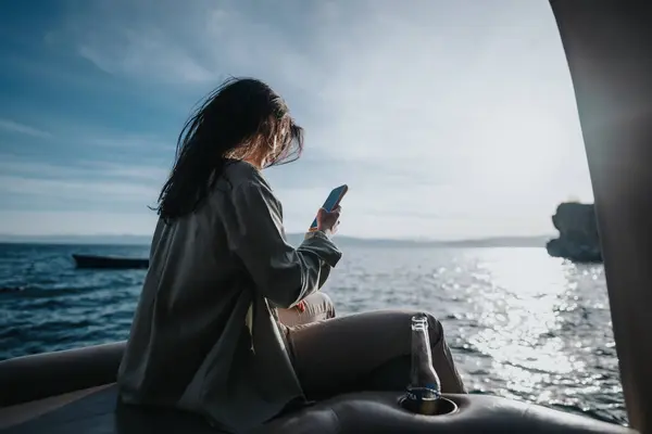 Een Gelukkig Jong Meisje Ontspant Een Boot Met Een Smartphone — Stockfoto