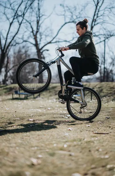 Young Man Enjoys Relaxed Day Performing Bike Stunts Wheelie Sunlit — Stock Photo, Image