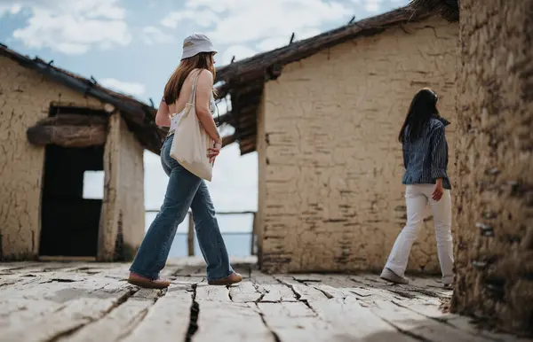 Captivating Scene Two Women Walking Ancient Sunlit Village Rustic Buildings — Stock Photo, Image