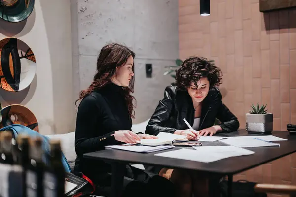 Focused Female Colleagues Working Together Table Stylish Office Setting Engrossed 스톡 사진