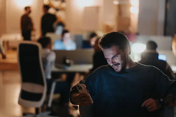 Hombre Joven Feliz Con Pelo Facial Sonriendo Mientras Usa Teléfono Imágenes De Stock Sin Royalties Gratis