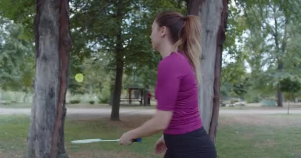 一个活跃的女人沉浸在一场羽毛球比赛中 展示着她的技巧 在一个充满繁华繁华繁华的都市公园里 充满了诱人的阳光 — 图库视频影像