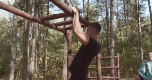 在森林的包围下 一个健康的年轻男性在户外用拉拉杆进行锻炼 展示了他们在美丽的大自然中的力量和对健康生活的承诺 — 图库视频影像