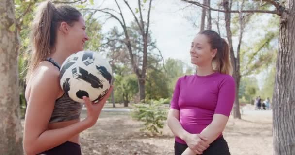 Две Спортсменки Стоят Вместе Парке Отдыхают Беседуют Готовятся Футбольной Тренировке — стоковое видео