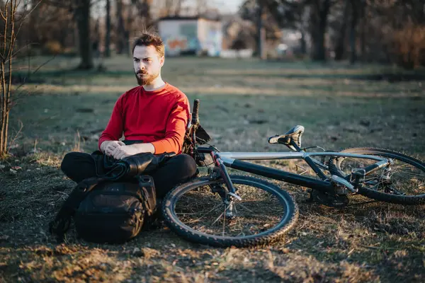 Jovem Irritado Com Cabelos Bagunçados Senta Perto Sua Bicicleta Montanha Imagens Royalty-Free