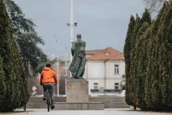 Kırmızı Ceketli Genç Bir Adam Sakin Bir Parkta Bisikletini Sürüyor Telifsiz Stok Fotoğraflar