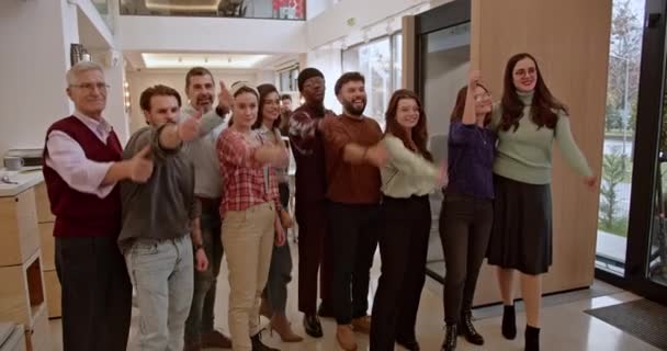 在现代办公环境中 一个跨代 多种族的企业员工群体高举大拇指庆祝成功 展示了不同人口统计中的团结和成就 — 图库视频影像