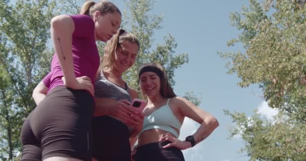 在公园锻炼后 一些活跃的女性体育朋友在电话中分享自己的笑声和社交媒体 — 图库视频影像