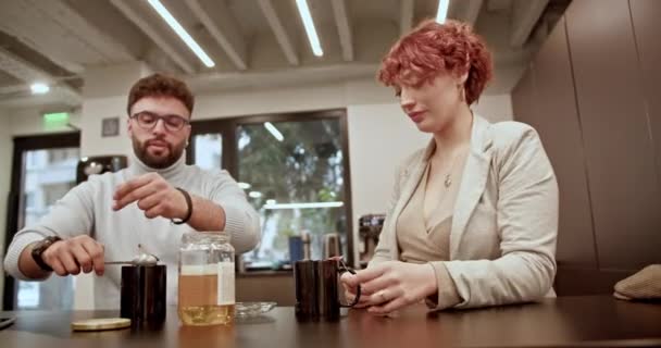 ビジネス同僚は オフィスで茶休憩中にカジュアルな瞬間を共有し 仕事の日にカマリーとリラクゼーションを促進しています — ストック動画