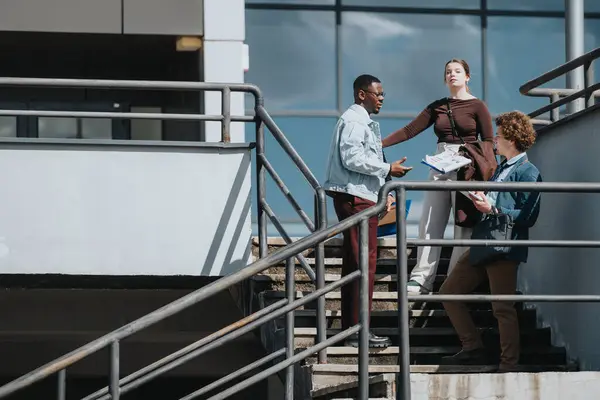 stock image Mixed race business team strategizes on outdoor staircase, engages in active discussion with documents under sunny sky.