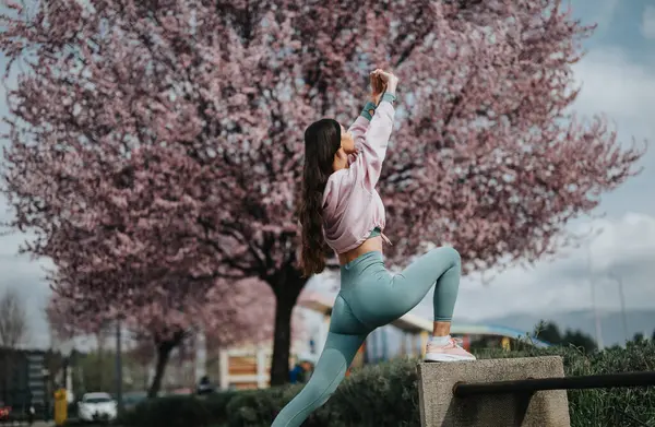 Active Young Woman Stretching Outdoors Blooming Cherry Blossoms Background Imagem De Stock