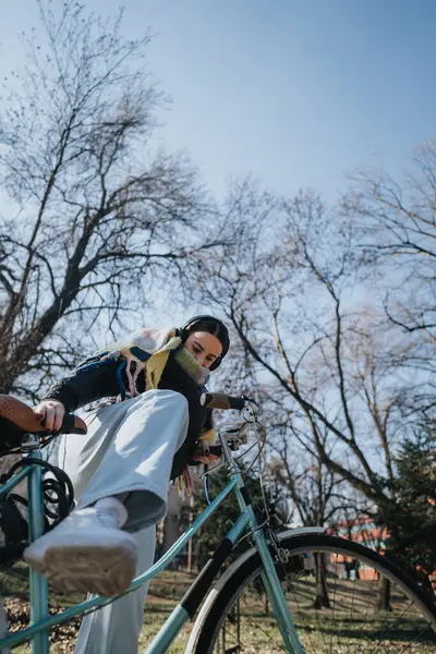 Young Female Cyclist Headphones Rides Leisurely City Park Enjoying Sunny Fotografias De Stock Royalty-Free