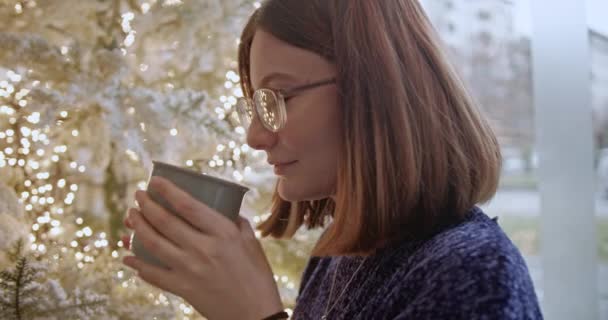 Festive Atmosphere Young Woman Sips Hot Beverage Surrounded Glowing Christmas — Videoclip de stoc