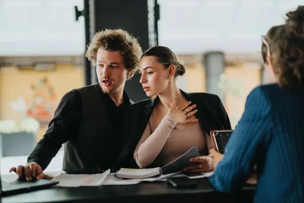 Stock image Focused business professionals collaborating on a project at a modern office setting, displaying teamwork and communication.