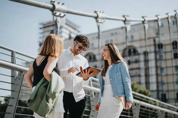 stock image Group of young professionals, male and female, discussing business ideas outdoors on a sunny day in an urban setting.