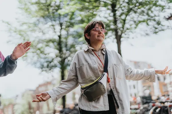 Stock image Woman feeling joyful in an outdoor setting surrounded by greenery, hanging out with friends on a sunny day.