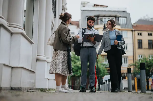 Stock image Young business associates strategizing, discussing a new project, and brainstorming ideas during a meeting in a vibrant urban city area.