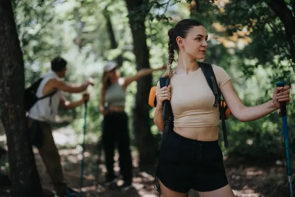 stock image Group of friends hiking in a lush forest, embracing the outdoors and enjoying the adventure together.