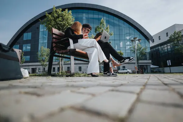 stock image Business workers using technology discussing new project, financial statements, marketing or sales strategy in an outdoor meeting with modern architecture background.