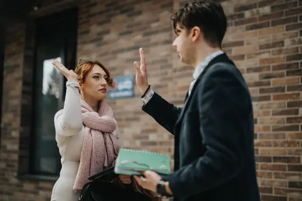 stock image Two professional business associates give a friendly high-five outside an office building, signifying partnership and teamwork.