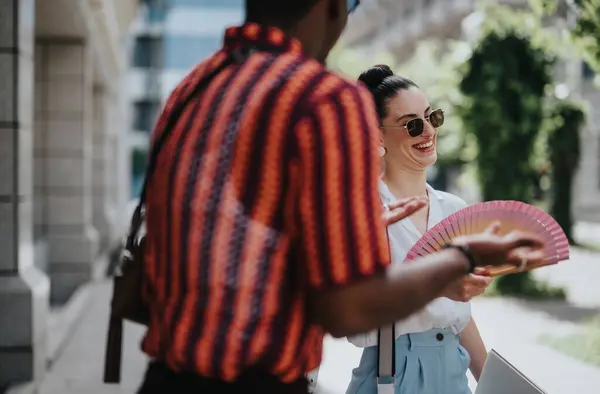 stock image Business professionals enjoying a casual conversation outside in a vibrant urban environment. The atmosphere is friendly and relaxed as they discuss work matters.