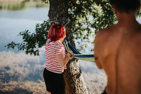 stock image Couple enjoys a summer adventure by setting up a hammock near a scenic lakeside. Captures fun, nature, and togetherness.