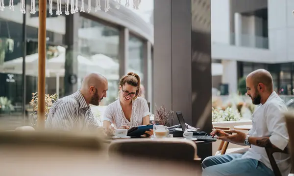 stock image Young business entrepreneurs strategizing and collaborating on a project at a coffee shop, emphasizing teamwork for improvement and growth.